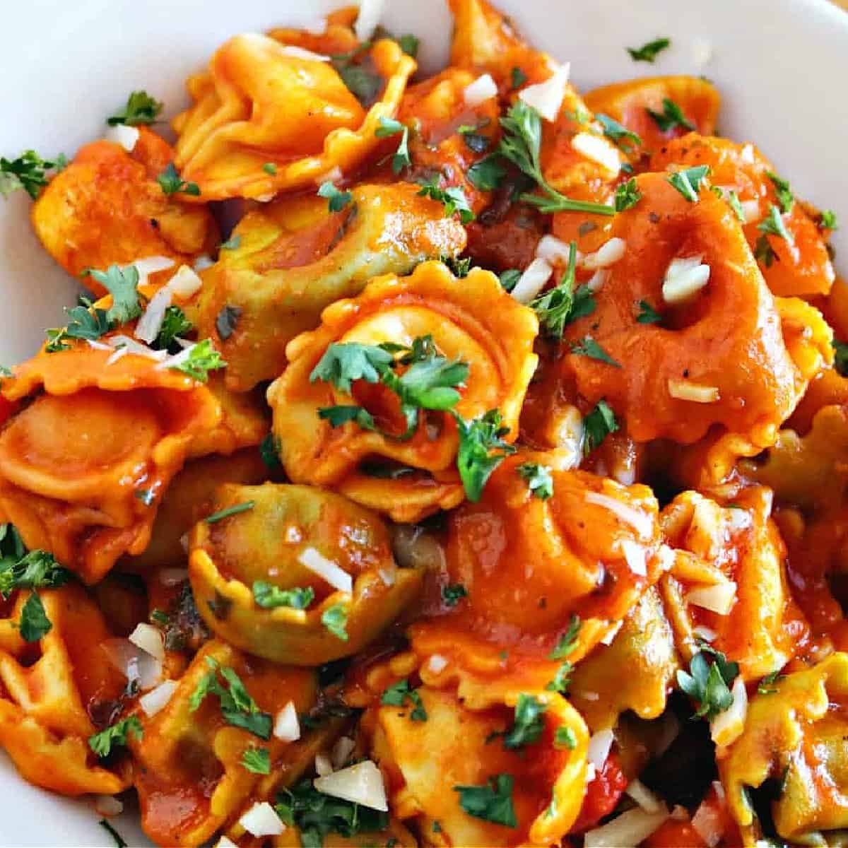 cheese tortellini in bowl with sauce.