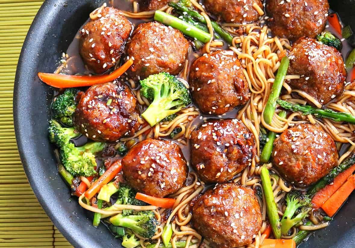 Sesame Chicken Meatballs in skillet with noodles.