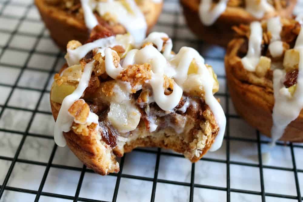 cinnamon roll apple pies with apple filling on wire rack. 