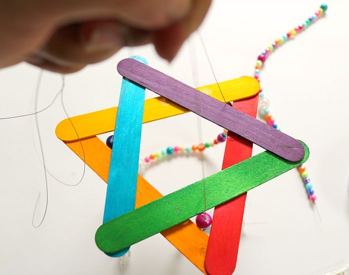 child hand beading on string.