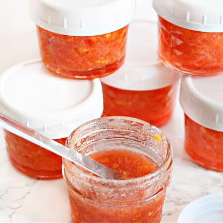 mason jars full of peach freezer jam.
