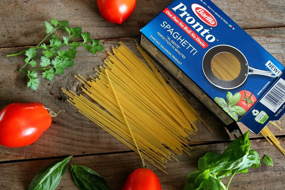 barilla spaghetti for pesto mozzarella chicken on cutting board.