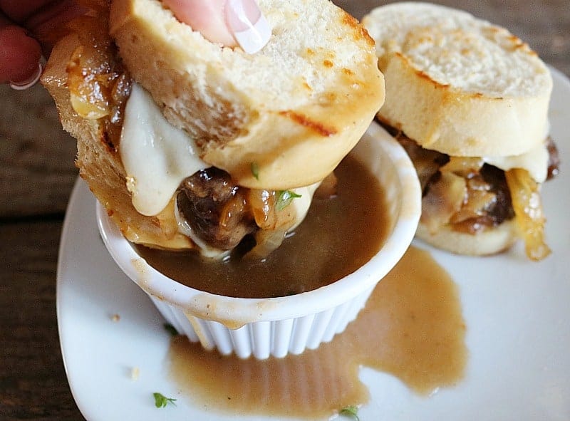 Beef sliders recipe being dipped into ramekin of au jus