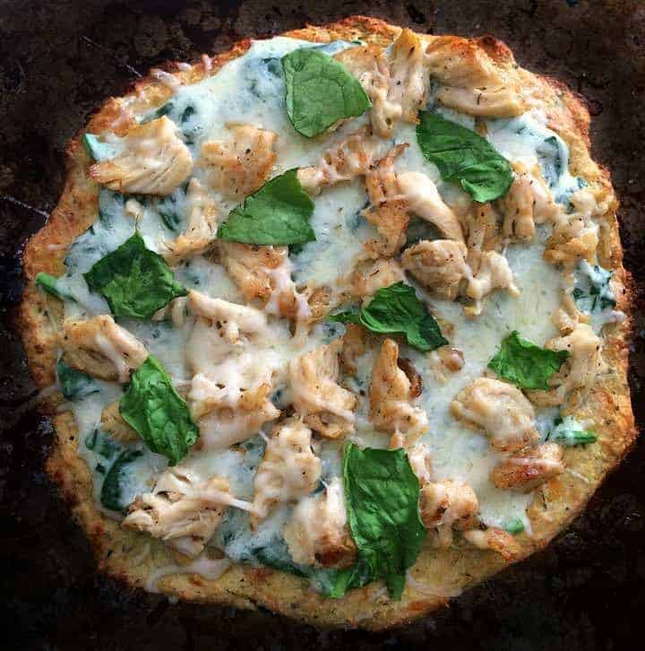 grilled chicken spinach pizza on pan. 