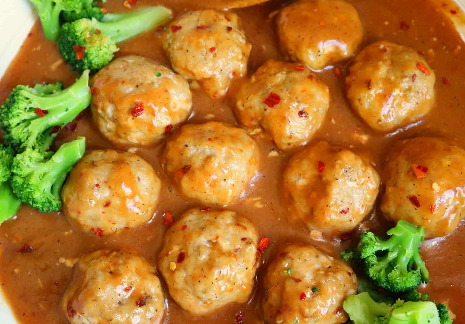 Broccoli and sauce in a bowl .