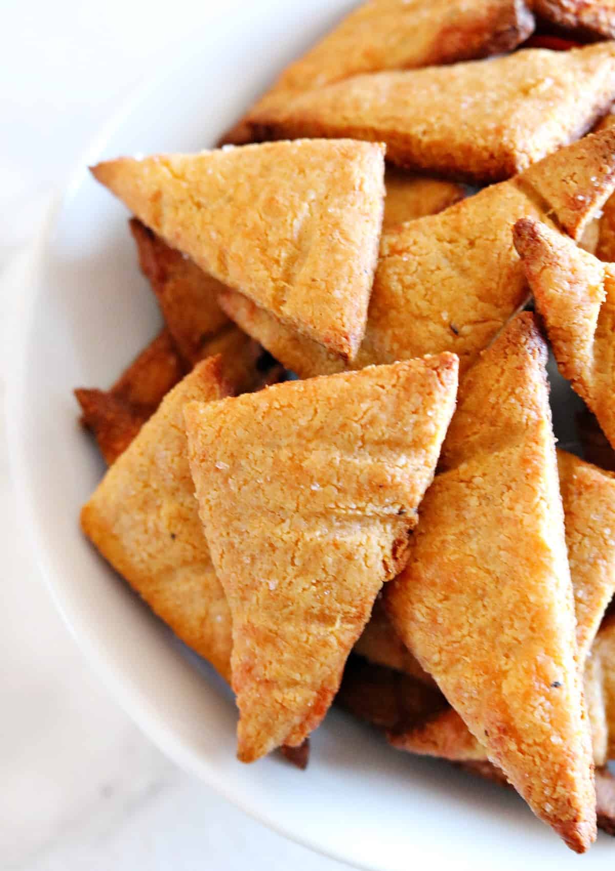 triangle shaped crackers on white plate.