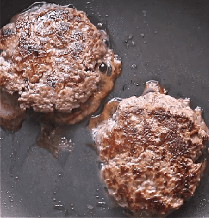 burgers cooking in skillet.