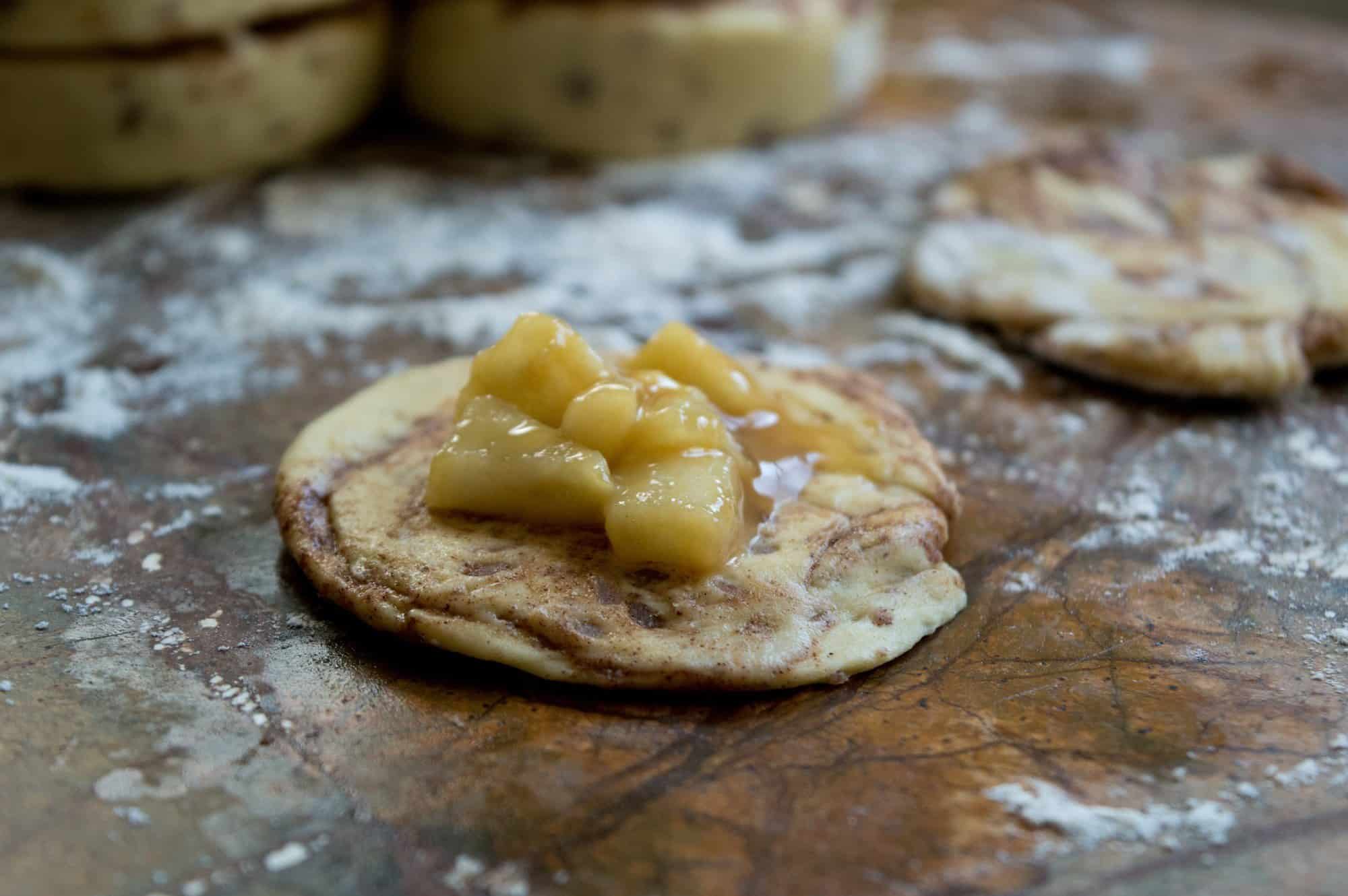 Flattened cinnamon roll topped with apples 