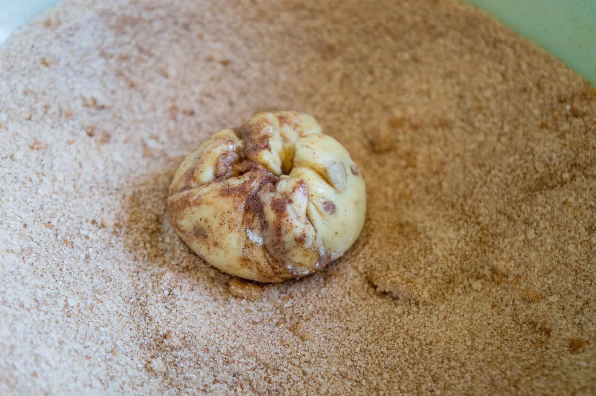 Bowl of cinnamon sugar with cinnamon roll apple pouch in center