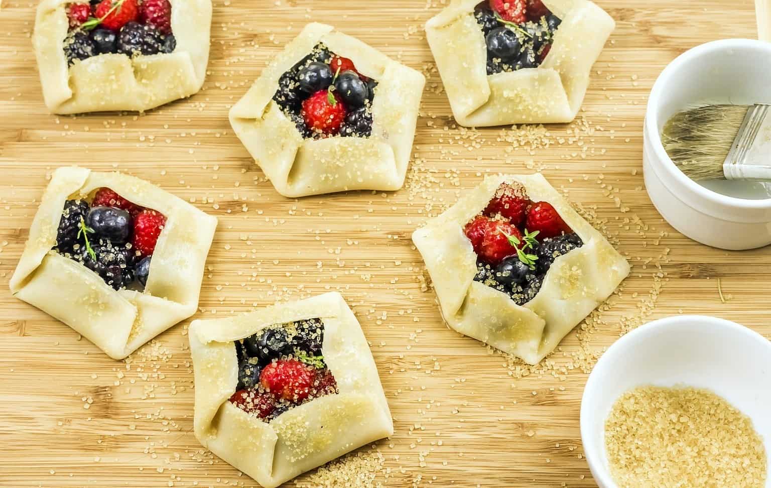 mini galette a french pastry with berries on cutting board.