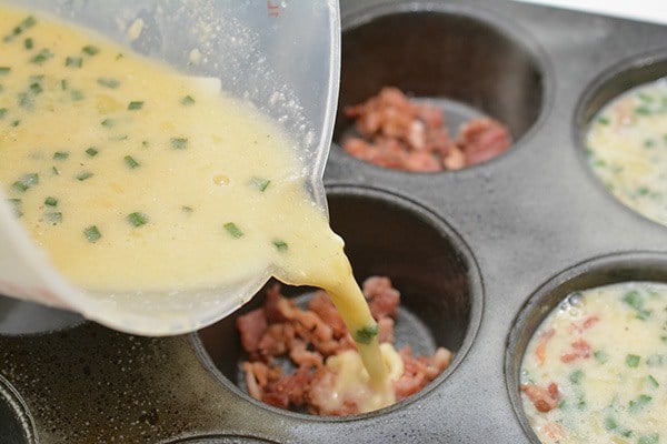 pouring egg mixture over bacon in muffin tin.