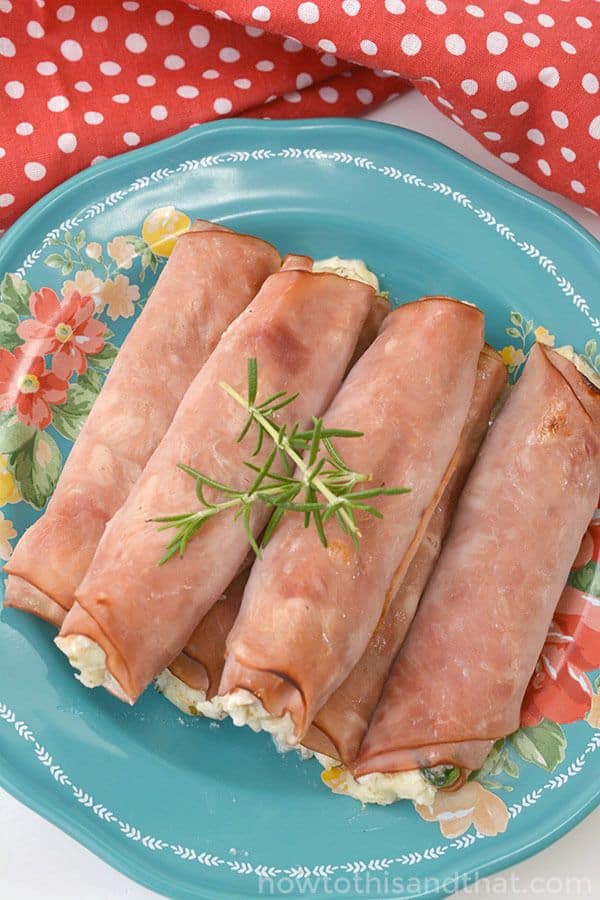 keto spinach and ricotta baked ham rollups on plate.