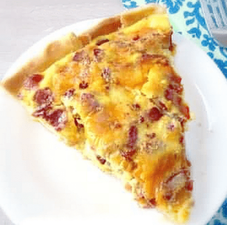 slice of bacon cheese quiche on plate.