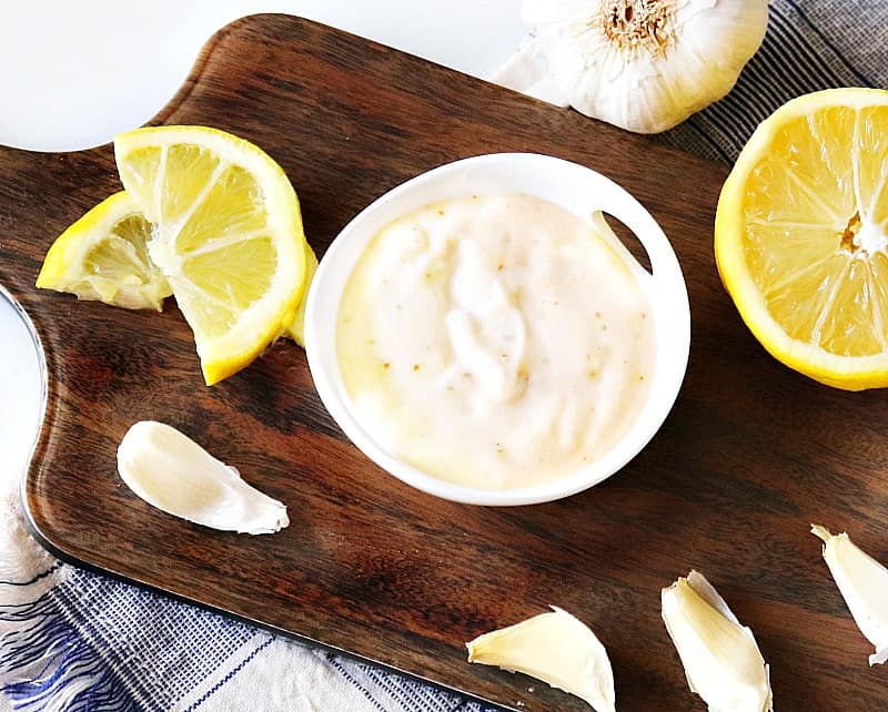 garlic aioli in a bowl on a cutting board.