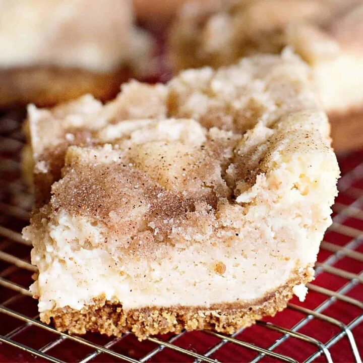 keto cheesecake bars with cinnamon on wire rack.