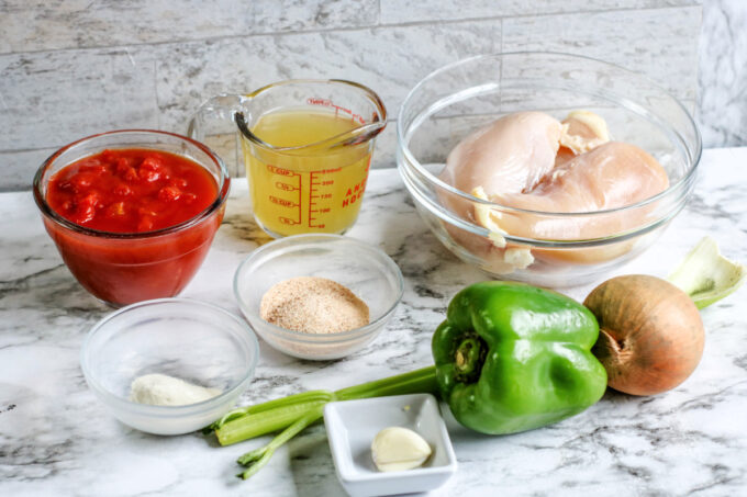 ingredients for creole chicken in dishes on table. 