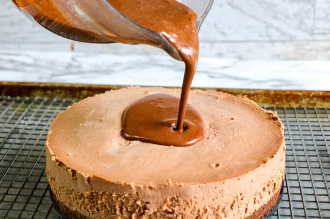 chocolate ganache being poured over dessert.