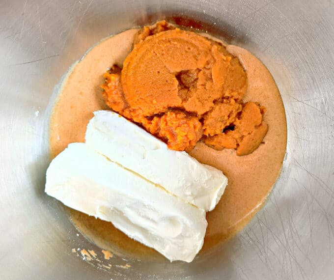 cream cheese and pumpkin puree in metal bowl.