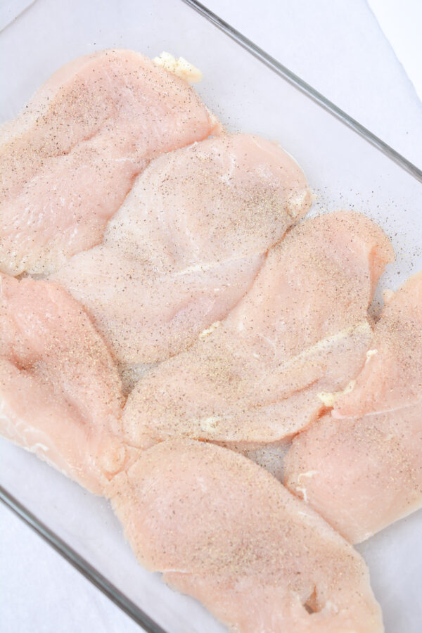 large chicken breast in glass pan.