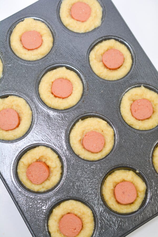 corn muffins with hot dogs in a muffin tins.
