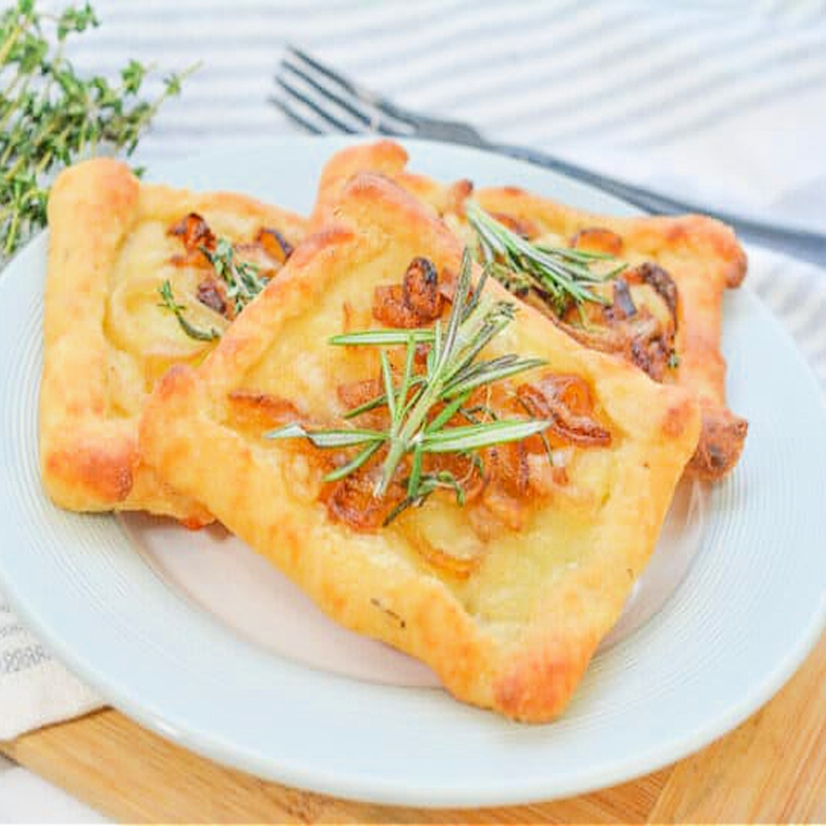 caramelized onions and brie tart appetizer on white plate.