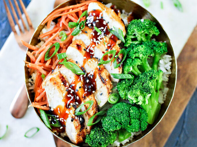 grilled chicken, broccoli and carrots in a bowl with General Tso's chicken sauce. 