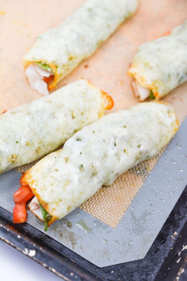 Freshly rolled keto caprese roll ups cooling‍ o‌n a baki‍n⁠g s​hee​t after bak⁠ing.
