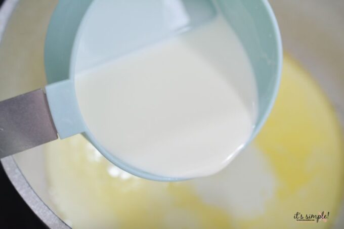 pouring heavy cream over melted butter for cheese sauce